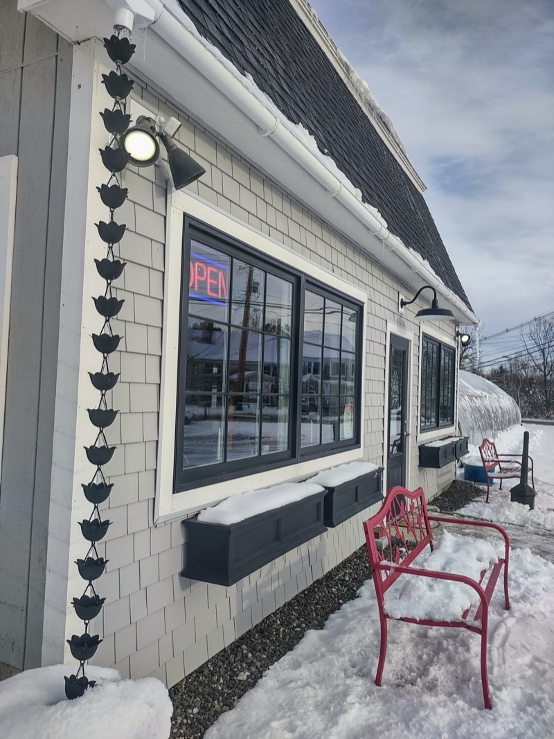 The side of the cafe after a snowfall, with the pink bench in the snow